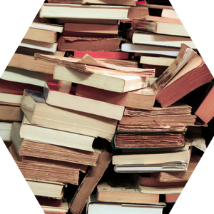 A hexagon filled with a photo of haphazardly piled books.