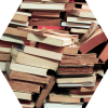 A hexagon filled with a photo of haphazardly piled books.